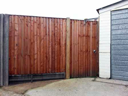 Close board gate + fence on concrete gravel board